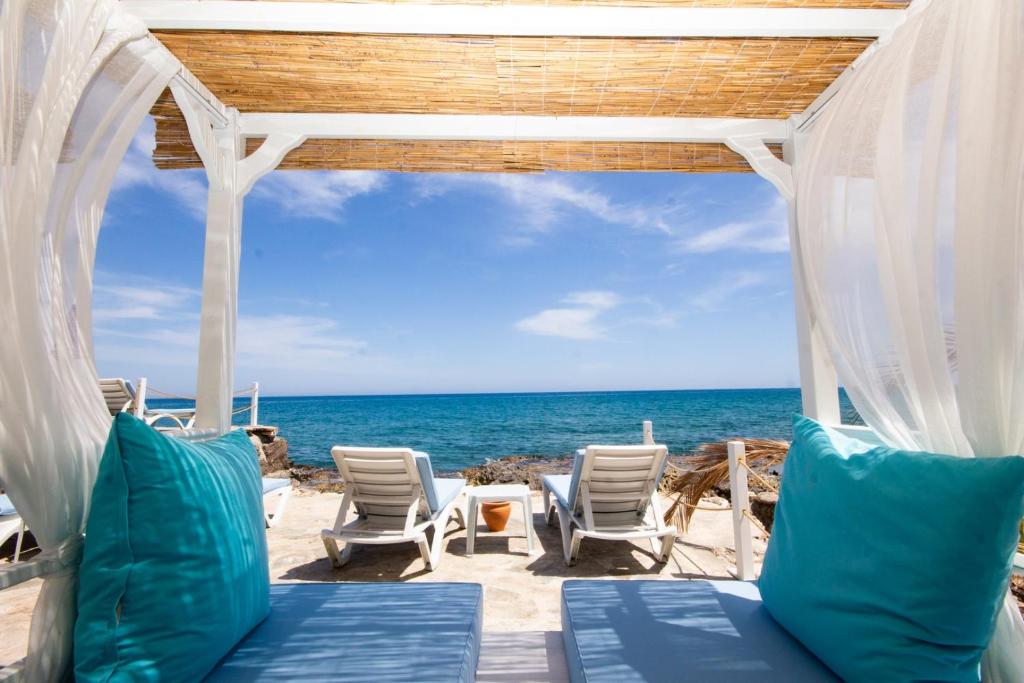 ErdemliMOJO OTEL BEACH的海滩上的凉亭,配有椅子和海洋
