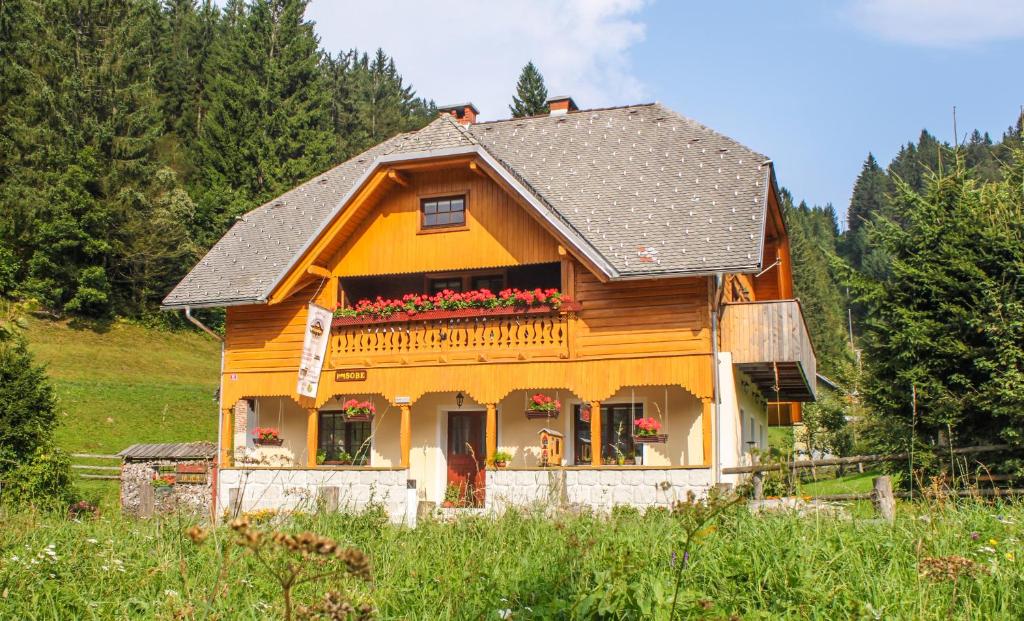 布莱德Homestead Zatrnik near Bled的一座小木房子,窗户上有鲜花