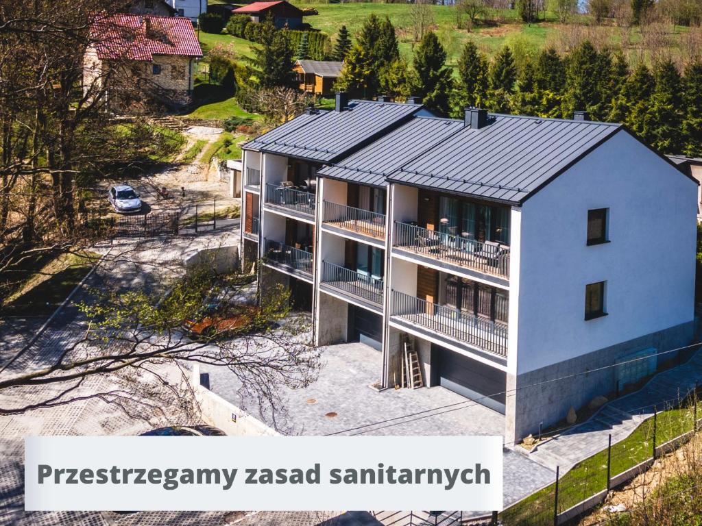 什切尔克Apartamenty SPOKOLOKO Skrzyczne Residence Korzenny i Kamienny的享有灰色屋顶房屋的空中景致