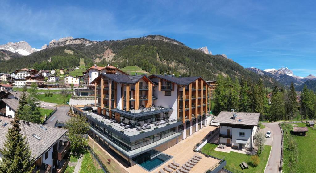 维哥迪法萨Ciampedie Luxury Alpine Spa Hotel的享有建筑的空中景观,以群山为背景