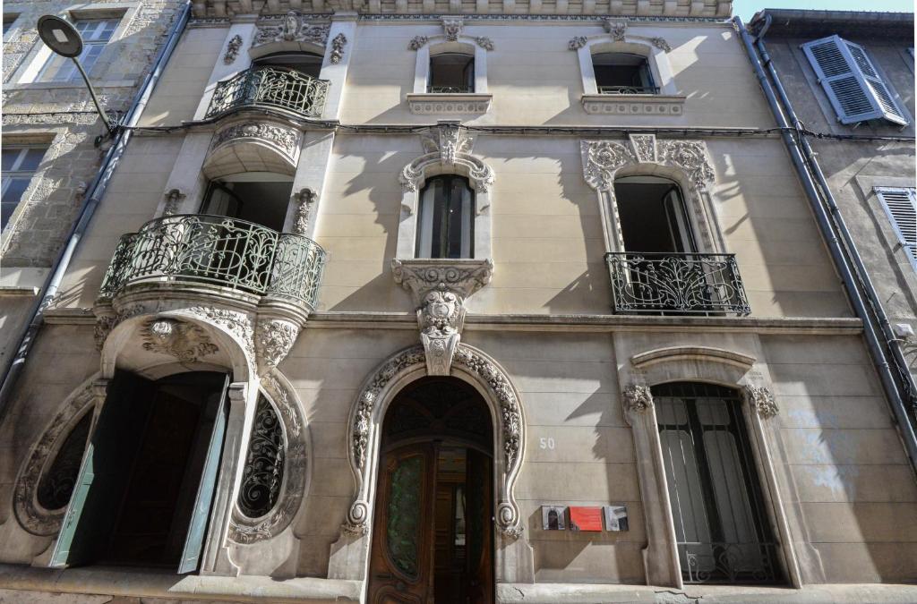 卡尔卡松La Maison de L' Ambassadeur Carcassonne的带阳台的建筑和街道上的一扇门
