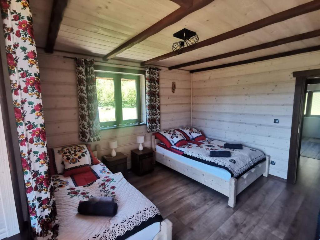 韦特利纳DoMarka całoroczny dom w Bieszczadach的小木屋内一间卧室,配有两张床