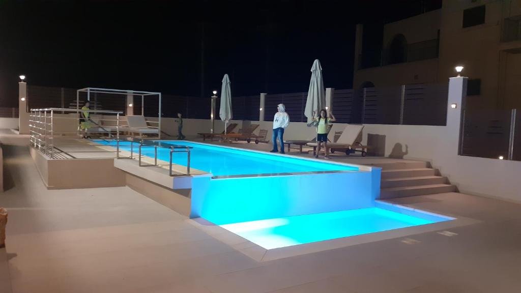 SkinésGiannis Villa的一个游泳池,晚上有人站在泳池周围