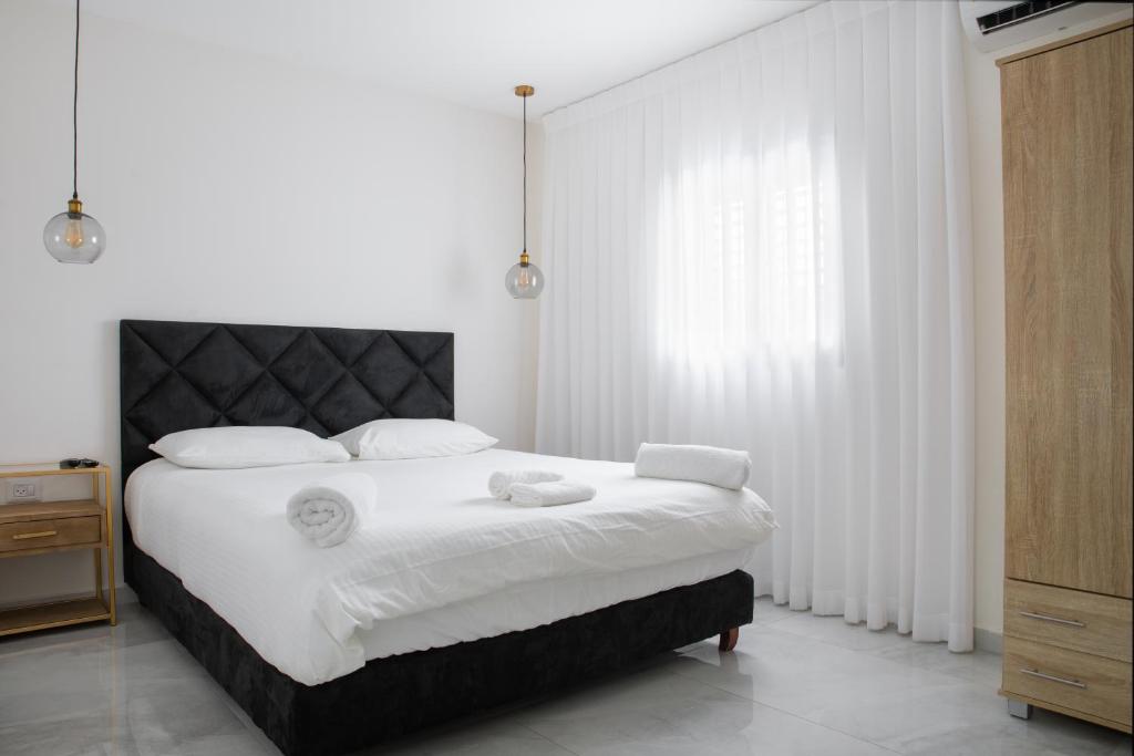 埃拉特By Eezy - צופית דירות אירוח的白色卧室配有一张带白色床单的大床