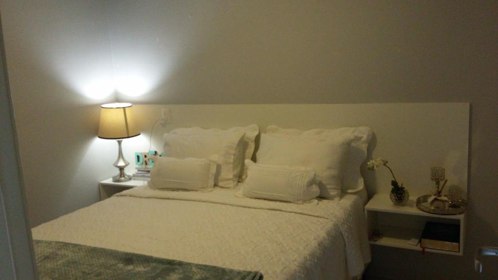 科伦巴Yes Vancouver Flats的一间卧室配有带白色枕头和灯的床