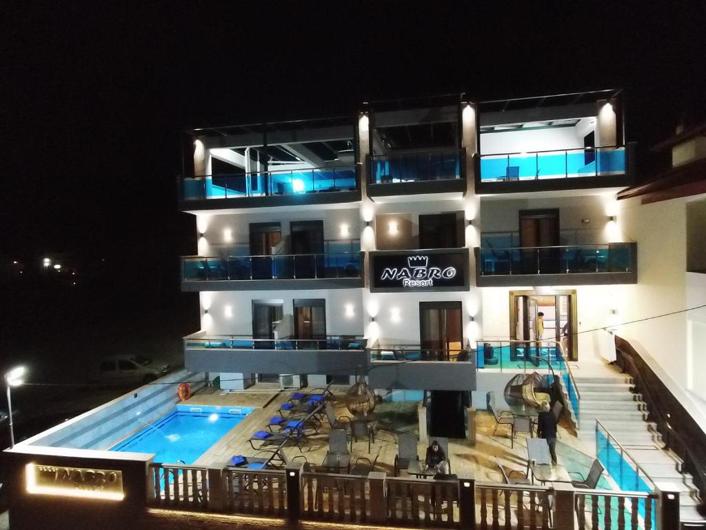 帕拉利亚卡泰里尼斯NABRO Resort的一座晚上设有游泳池的建筑