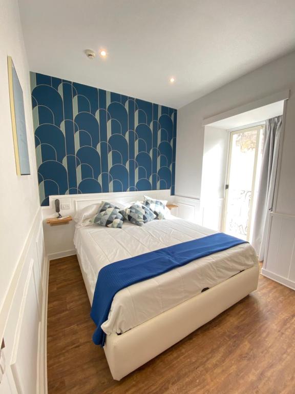 那不勒斯那不勒斯欧洲酒店的一间卧室设有一张床和蓝白色的墙壁