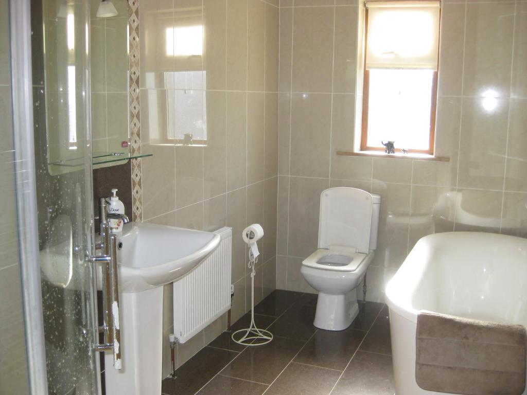贝尔马利特Broadhaven Bay View Private House的浴室配有盥洗盆、卫生间和浴缸。