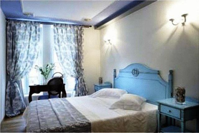 纳弗帕克托斯阿宏提可皮普斯酒店的一间卧室设有蓝色的床和窗户。