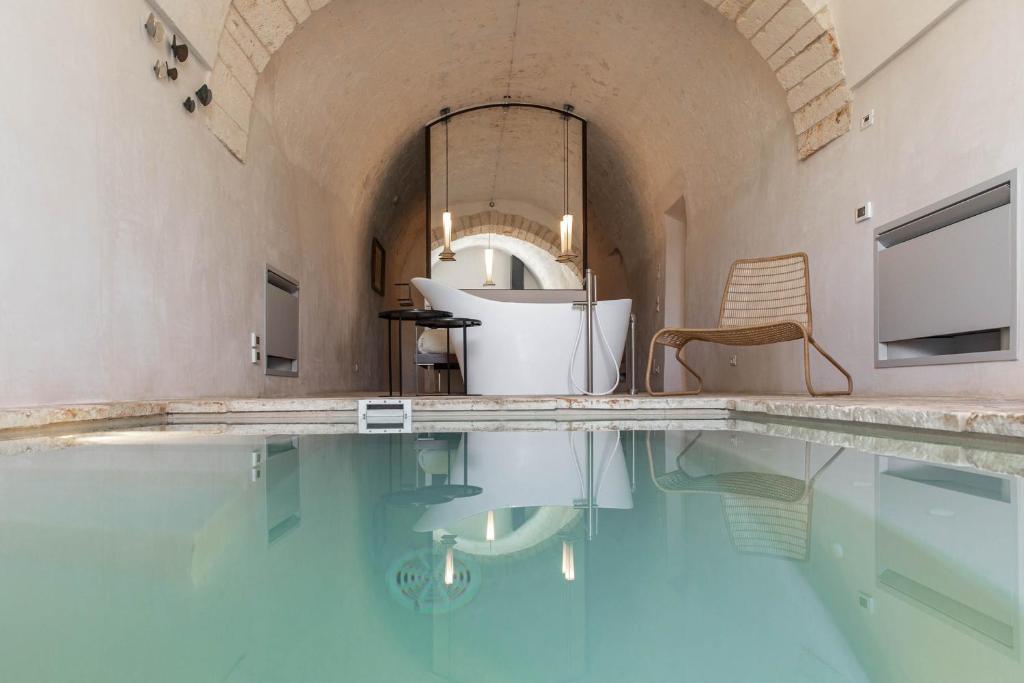 奥斯图尼Il Sogno delle Benedettine的一个带浴缸和椅子的游泳池