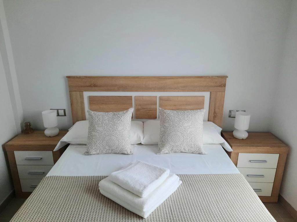普拉森西亚Apartamentos Clavero 10的卧室配有一张带两个枕头的大白色床
