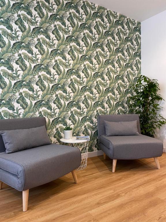 卡利亚里Vento Suites的客厅配有两把椅子,拥有绿色和白色的壁纸