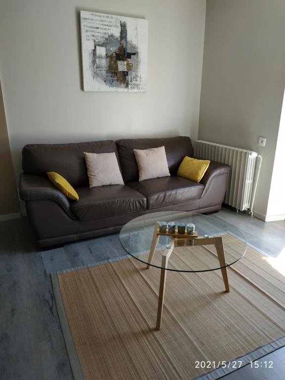 欧里亚克appartement avec terrasse的带沙发和玻璃茶几的客厅