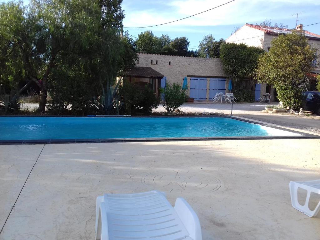 Saint-EstèveMas Fany et Olivier的房屋前带两把白色椅子的游泳池