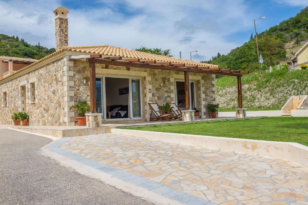 埃费奥纳斯Villas Porto Kamini Afionas Corfu的石头房子,旁边设有凉亭