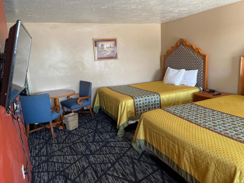 里弗顿Riverton Inn & Suites Riverton的酒店客房设有两张床和一台平面电视。
