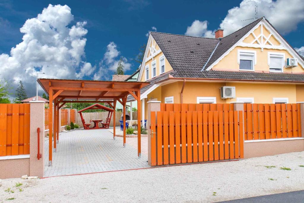 鲍洛通凯赖斯图尔Holiday home Balatonkeresztur 24的一座带橙色围栏和凉亭的房子
