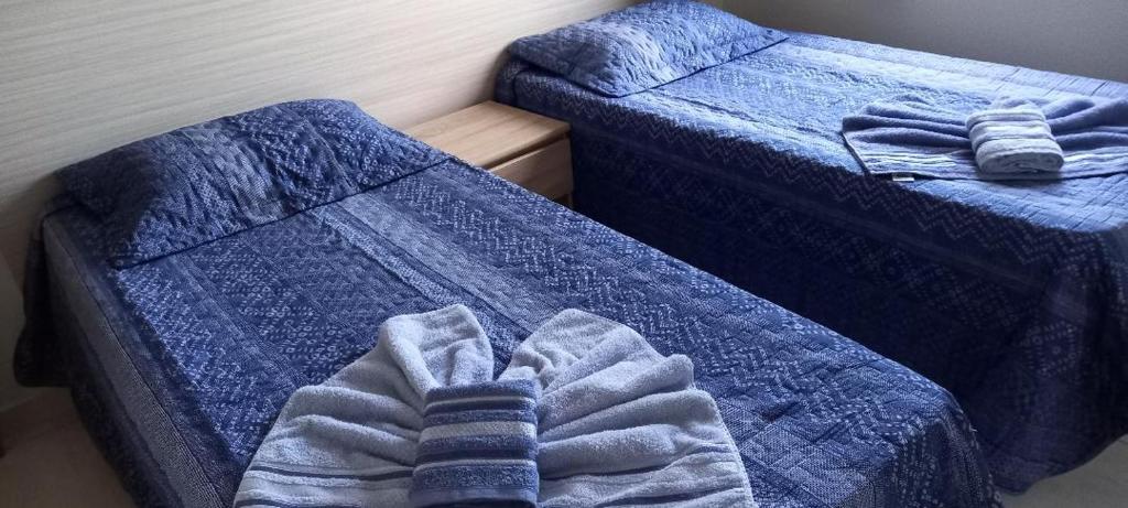 阿瓜斯迪林多亚Apartamento Diamante的配有蓝色棉被的客房内的两张单人床