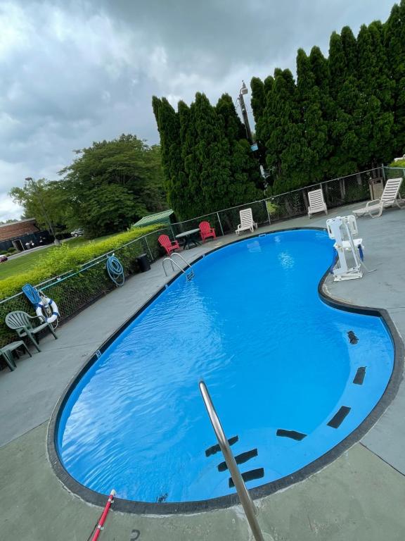 曼彻斯特曼彻斯特苏格兰汽车旅馆的一个带椅子和树木的大型蓝色游泳池
