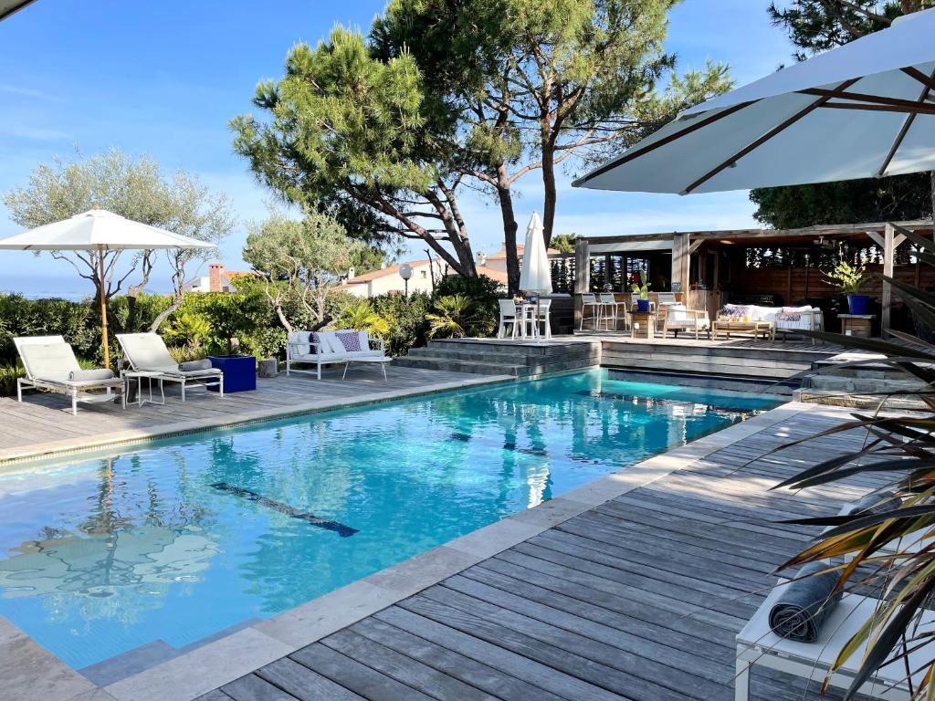 波尔蒂乔Les Suites d'Agosta的一个带椅子和遮阳伞的游泳池