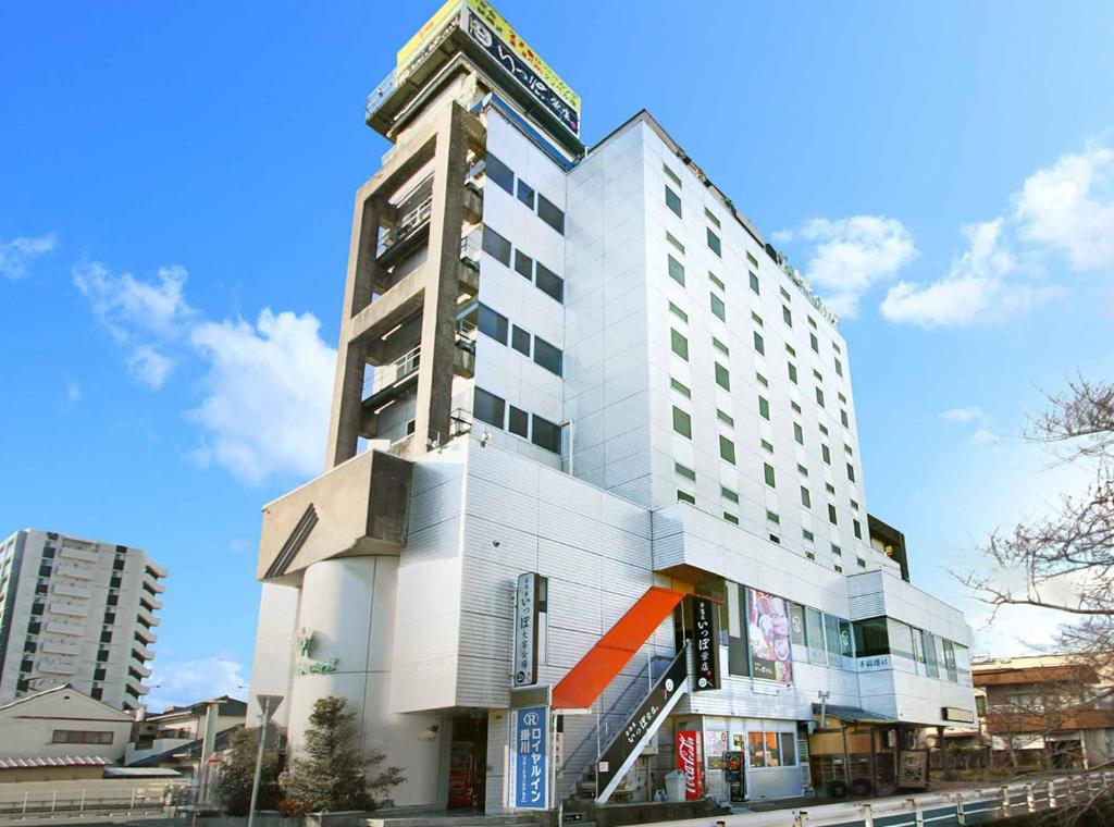 挂川市Royal Inn Kakegawa (Station Hotel 2)的一座高大的白色建筑,上面有时钟