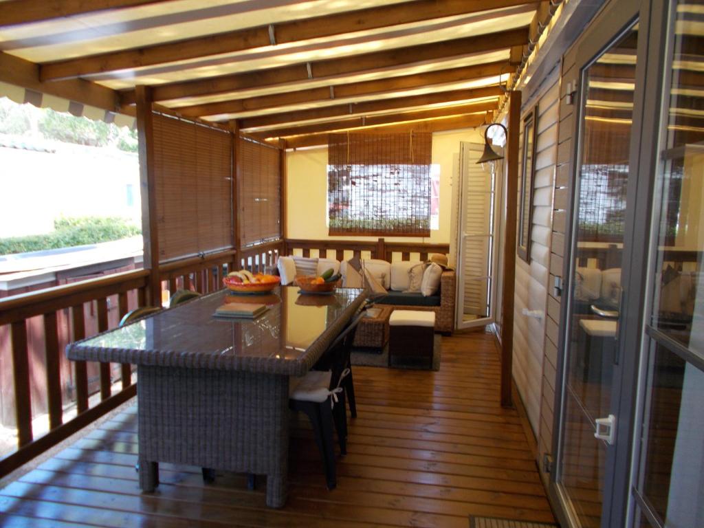 加斯泰mobilhome charme funpass et wifi inclus的带阳台的客房配有桌子和沙发