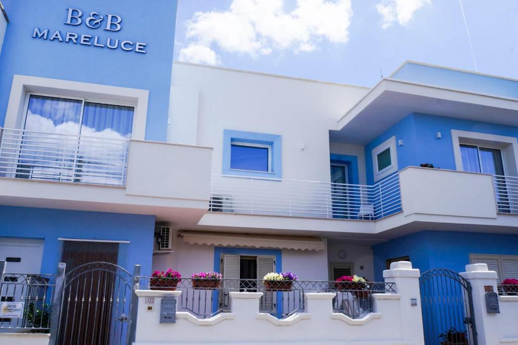 切萨雷奥港Mareluce B&B的蓝色和白色的建筑,阳台上有鲜花