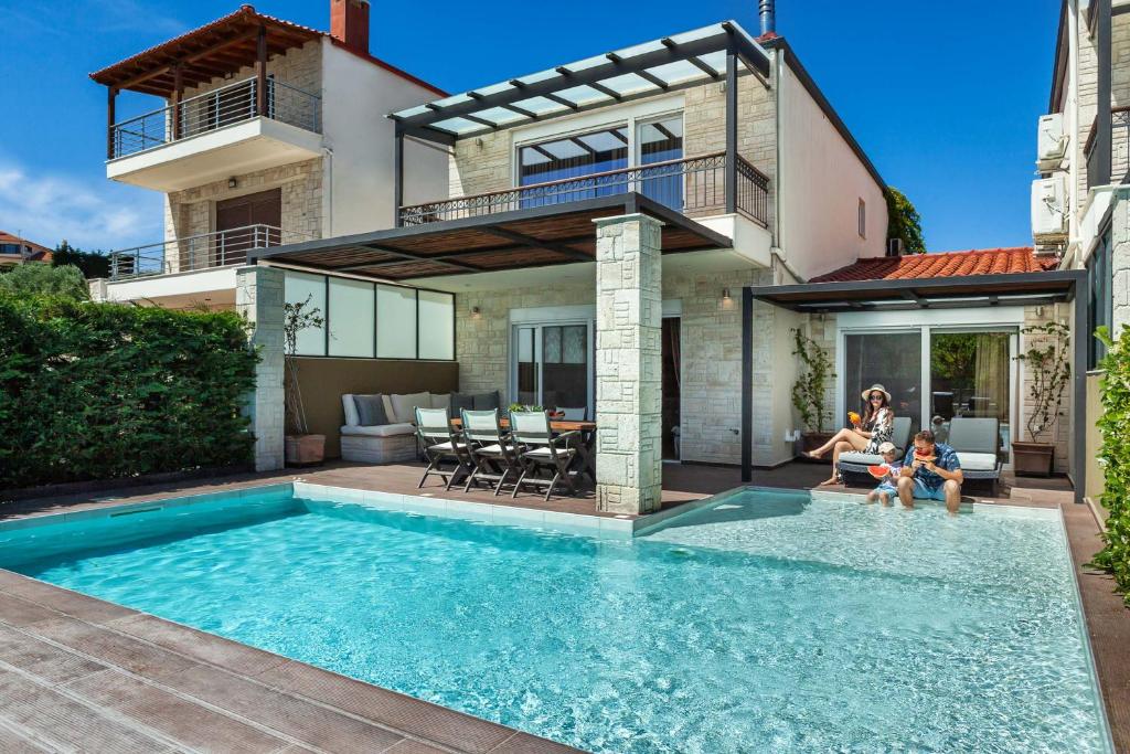 卡尼奥提Sunny Villas Exclusive的房屋前有游泳池的房子