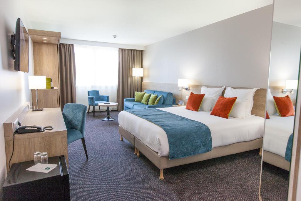 格拉迪尼昂Best Western Hotel Le Bordeaux Sud的酒店客房设有一张大床和一张书桌。