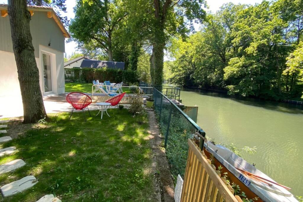 奥尔良Loire Nature, proche de la ville的河畔的院子,配有桌椅