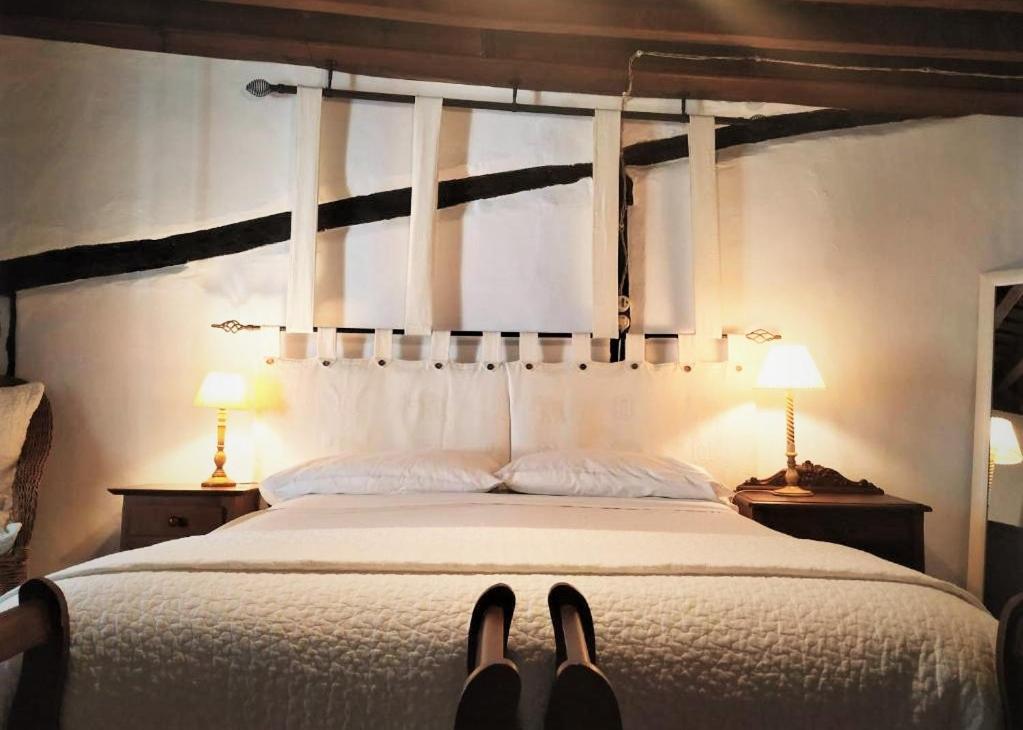 赫尔特卡萨白素娜乡村民宿的一间卧室配有一张带两盏灯和两双鞋的床