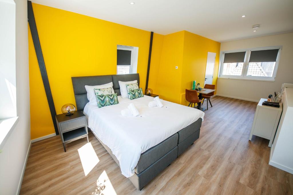 登博斯Deluxe 35m2 City Center Suite - with Views的一间卧室设有一张黄色墙壁的大床