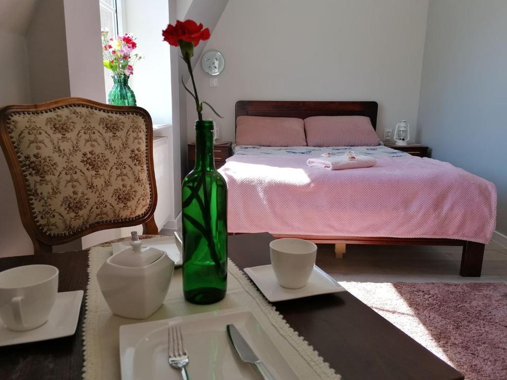 乌斯特卡Pokoje Alicja Ustka的一间卧室配有一张带绿花瓶的床铺,桌子上摆放着绿色花瓶