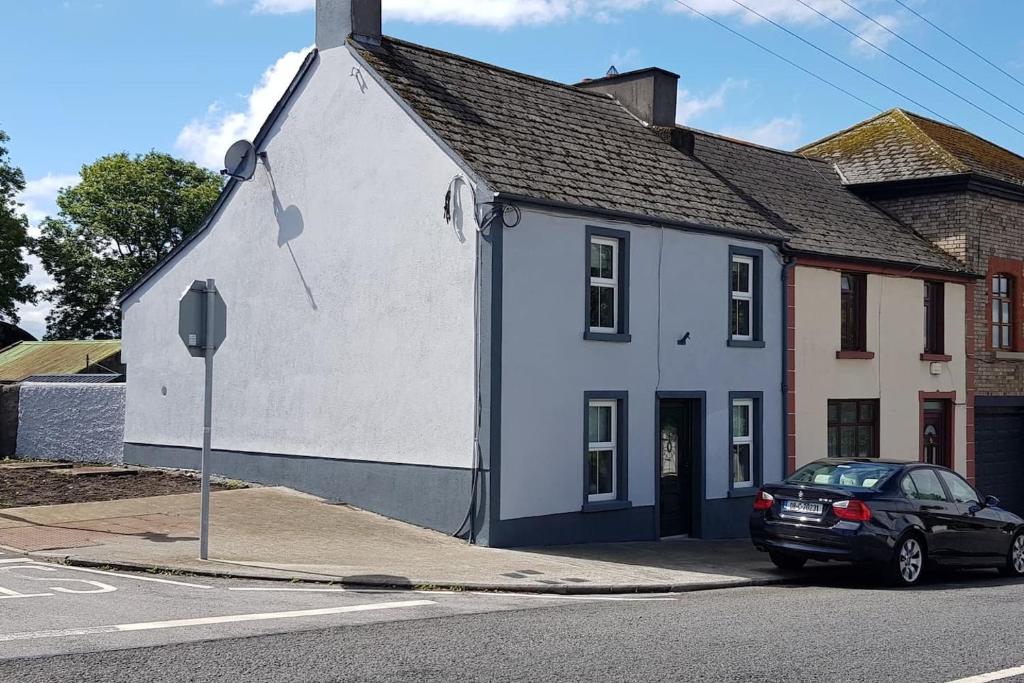 巴纳赫Cosy Townhouse on The Hill in Ireland的前面有一辆汽车停放的白色房子