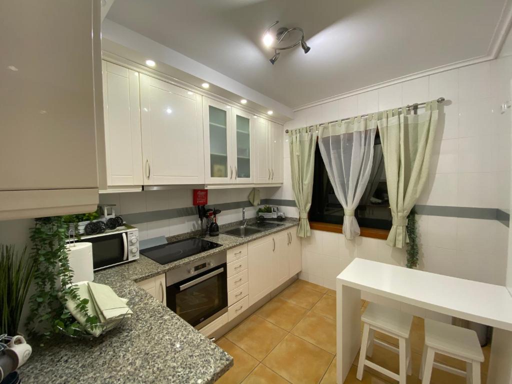 阿威罗Vagueira casa férias的厨房配有白色橱柜和台面