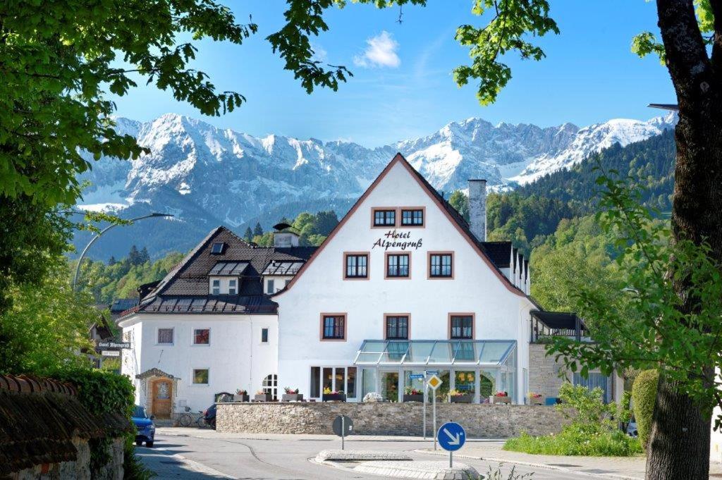 加尔米施-帕滕基兴Hotel garni Alpengruss的一座白色的大建筑,背景是群山