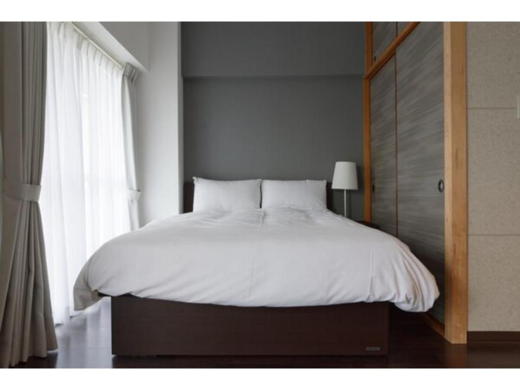 川口市WALLABY HOUSE - Vacation STAY 38655v的卧室配有白色的床和窗户