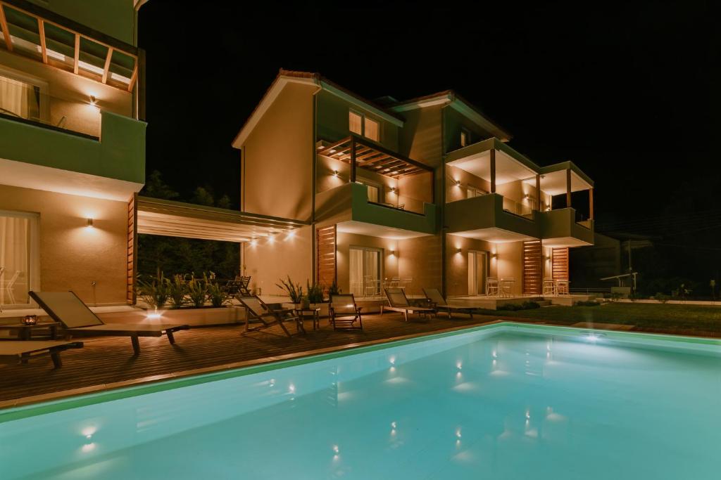普里诺斯Alion apartments的夜间带游泳池的别墅