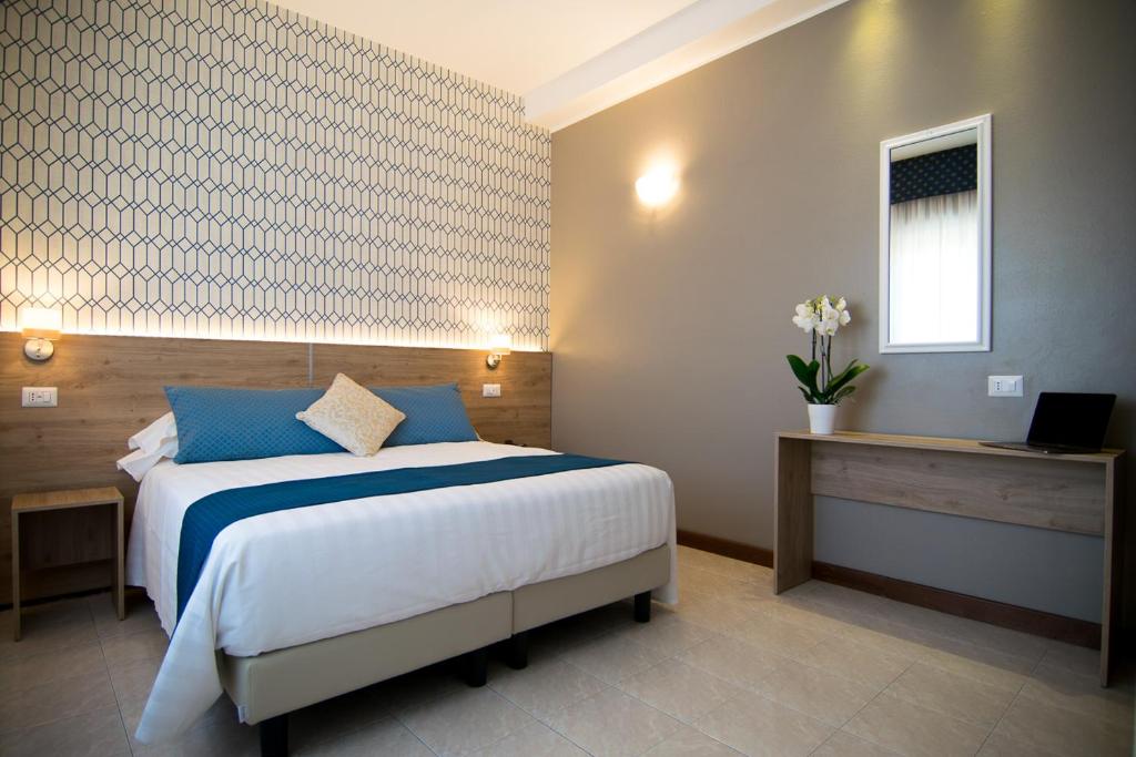 罗马太平洋酒店的一间卧室配有一张带蓝色枕头的大床