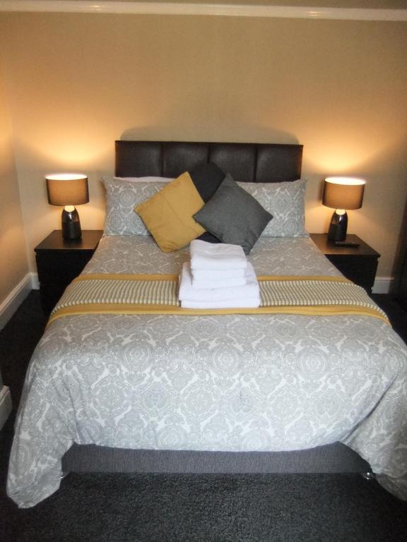 布莱克浦Dewsbury House的一间卧室配有一张带枕头的床和两盏灯。