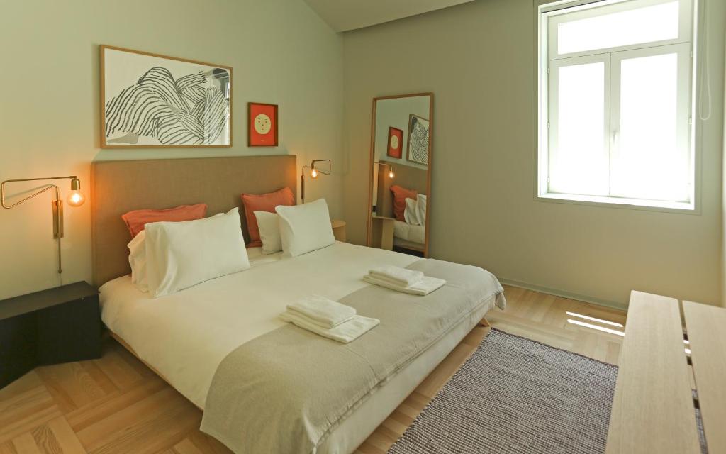 波尔图Prime Riverside的一间卧室配有一张大床和两条毛巾