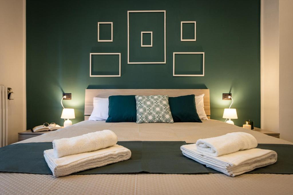 阿罗纳Green Pearl ✰✰✰✰✰ Appartamento a 100 metri dal lago的一间卧室设有一张大床和绿色的墙壁