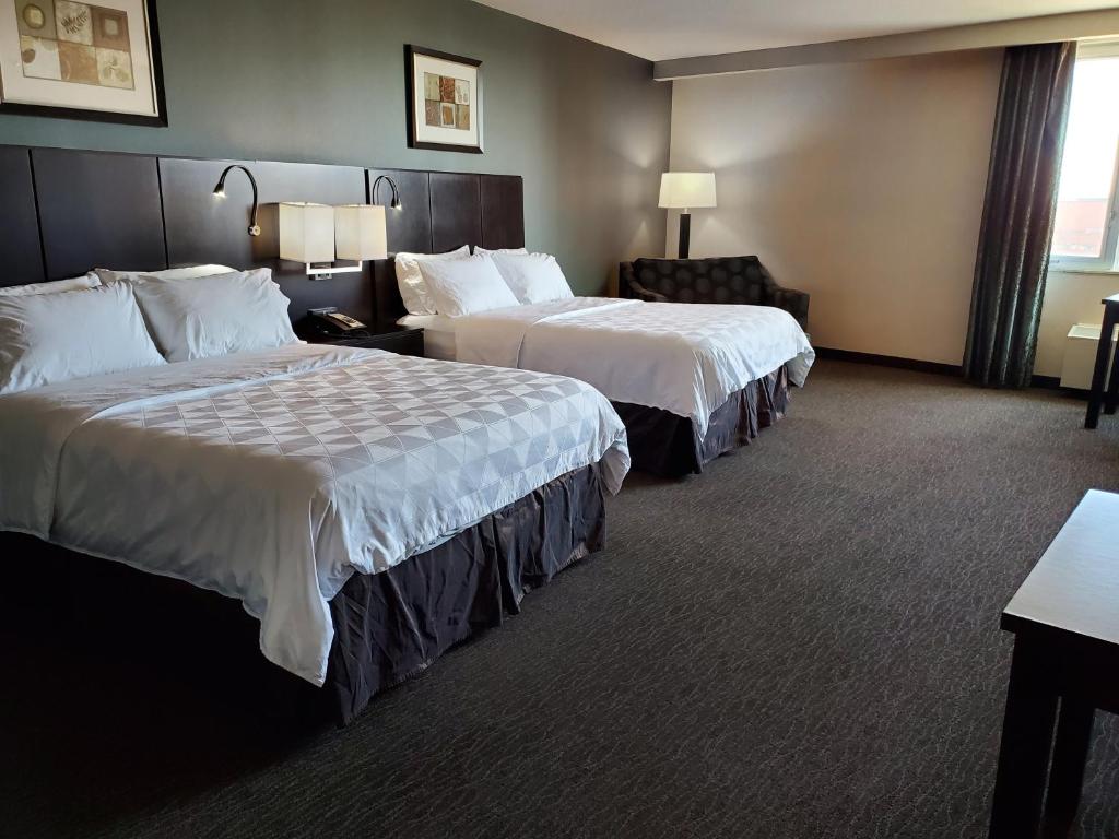 萨斯卡通萨斯卡通市中心假日酒店的酒店客房,配有两张床和椅子