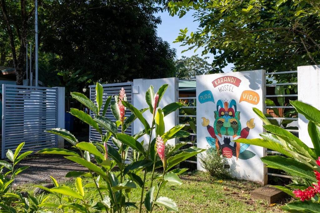 乌维塔Karandi Hostel的围栏旁花园的标志