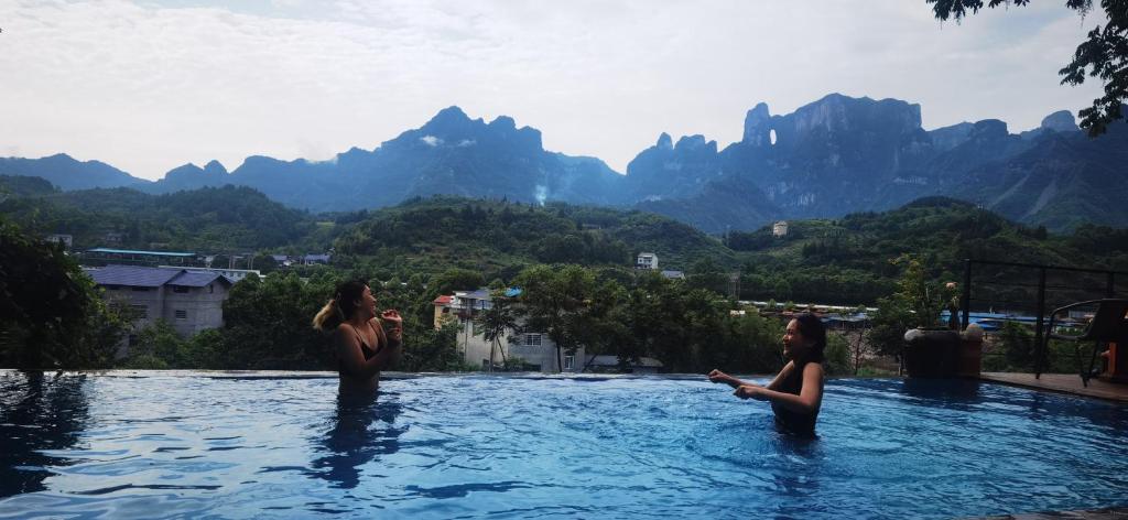 张家界田舍花园民宿的两名女性在一座山地游泳池里