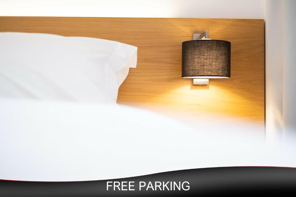 帕特雷City Loft Hotel的一张带免费停车位标志和灯的床