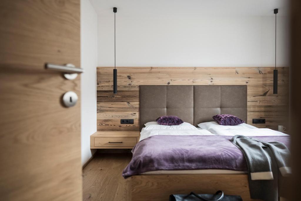 塞斯托Gamz Villa的一间卧室配有一张带紫色床单和枕头的床。