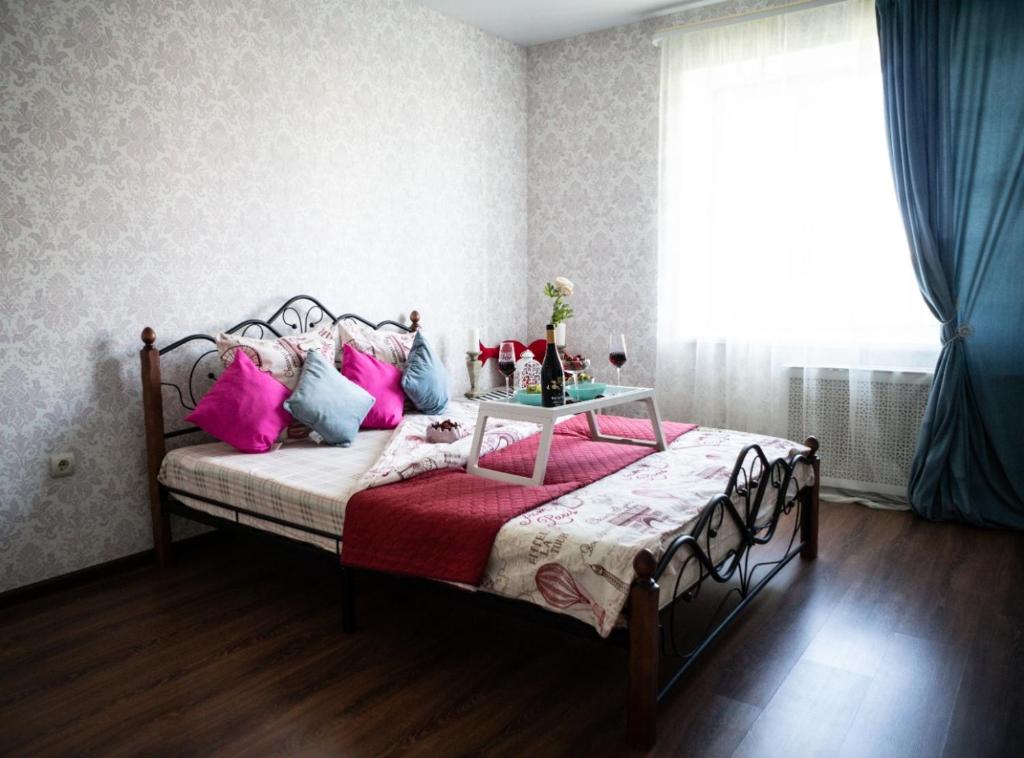 乌法Sky room от Resident Ufa的一间卧室配有带粉红色和蓝色枕头的床