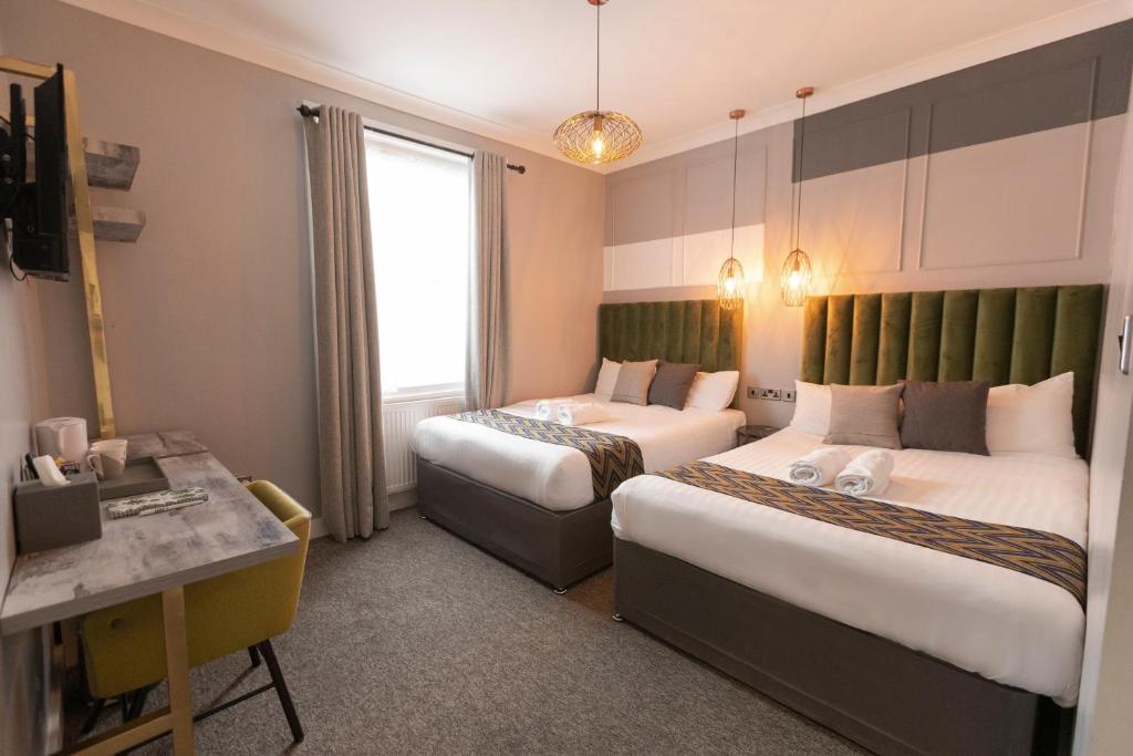 伦敦GRN康福特尔酒店的酒店客房配有两张床和一张书桌
