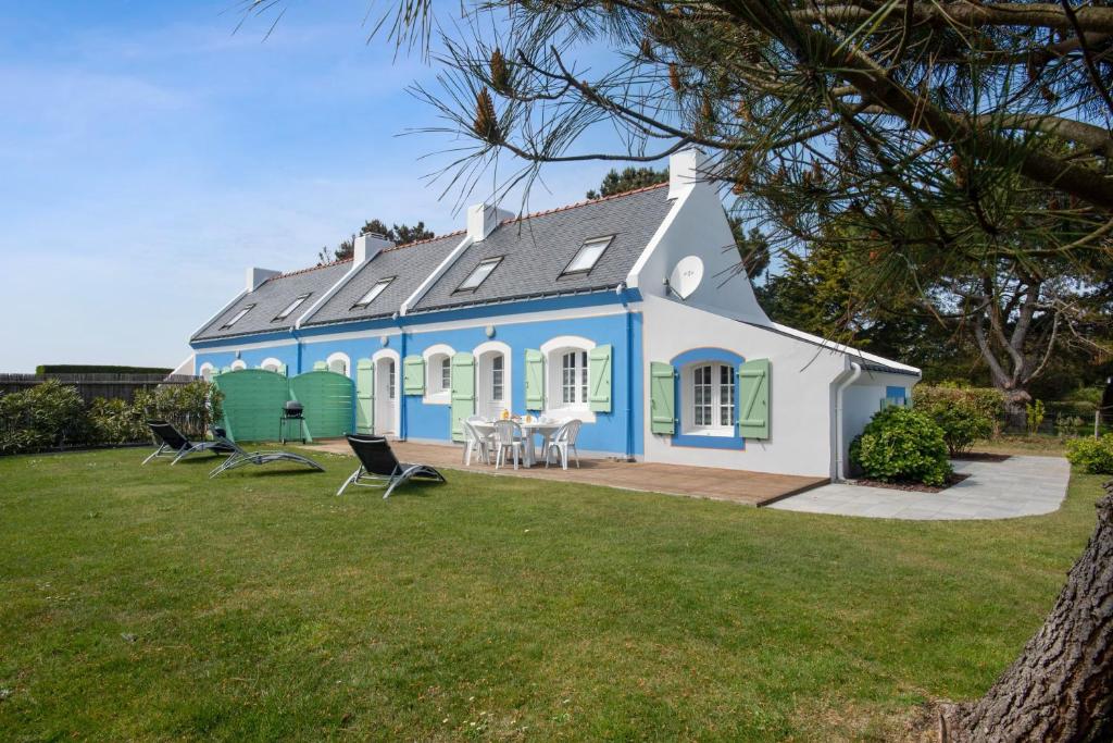 班戈Maison de 3 chambres a Bangor a 500 m de la plage avec jardin clos et wifi的蓝色和白色的房子,有院子